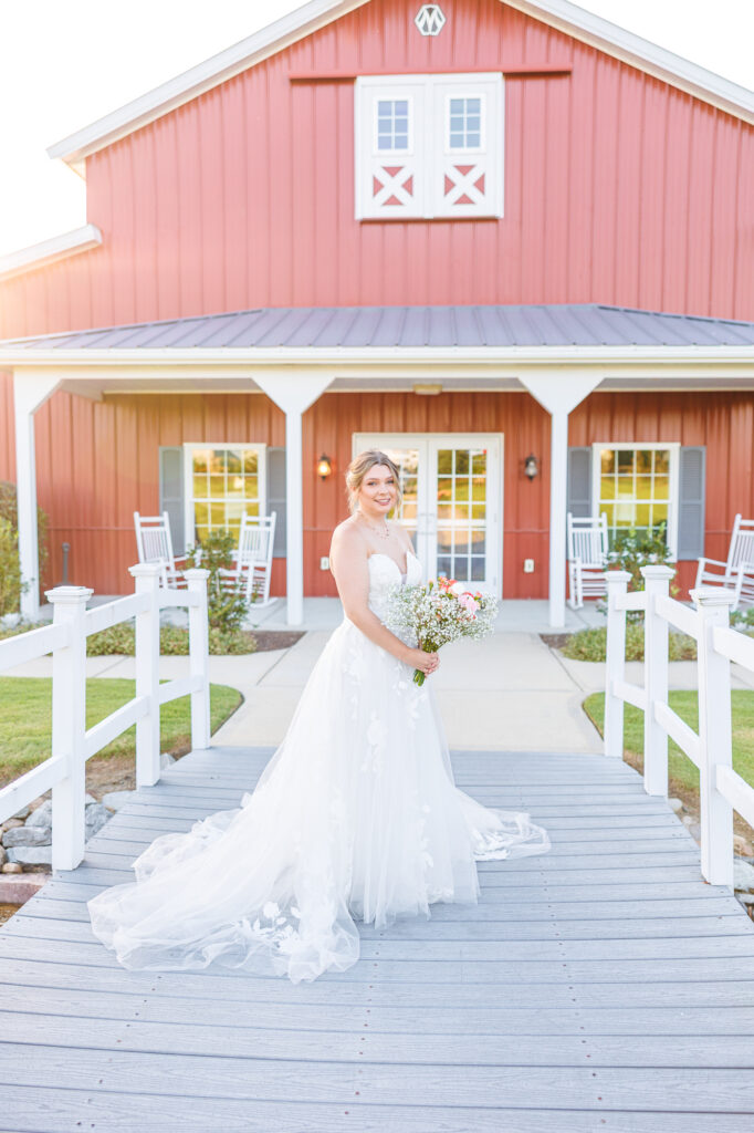 Bride in a white lace wedding gown holding a pastel bouquet at Carrollock Farms, a rustic barn wedding venue near Raleigh, North Carolina