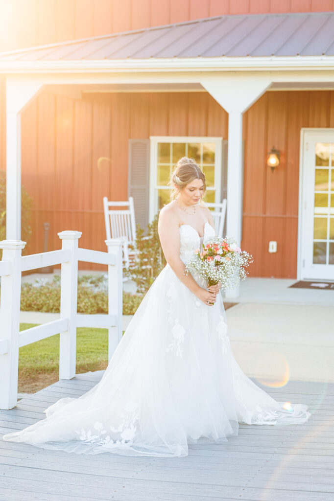 Bride in a white lace wedding gown holding a pastel bouquet at Carrollock Farms, a rustic barn wedding venue near Raleigh, North Carolina