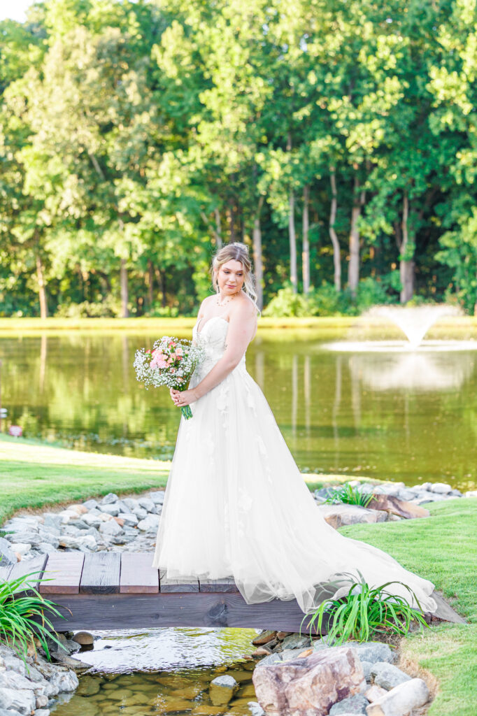 Bride in a white lace wedding gown holding a pastel bouquet at Carrollock Farms, a rustic barn wedding venue near Raleigh, North Carolina