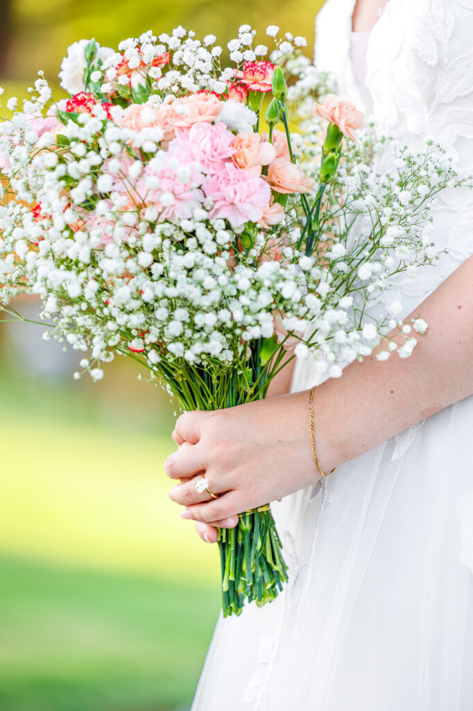 Bride in a white lace wedding gown holding a pastel bouquet at Carrollock Farms, a rustic barn wedding venue near Raleigh, North Carolina