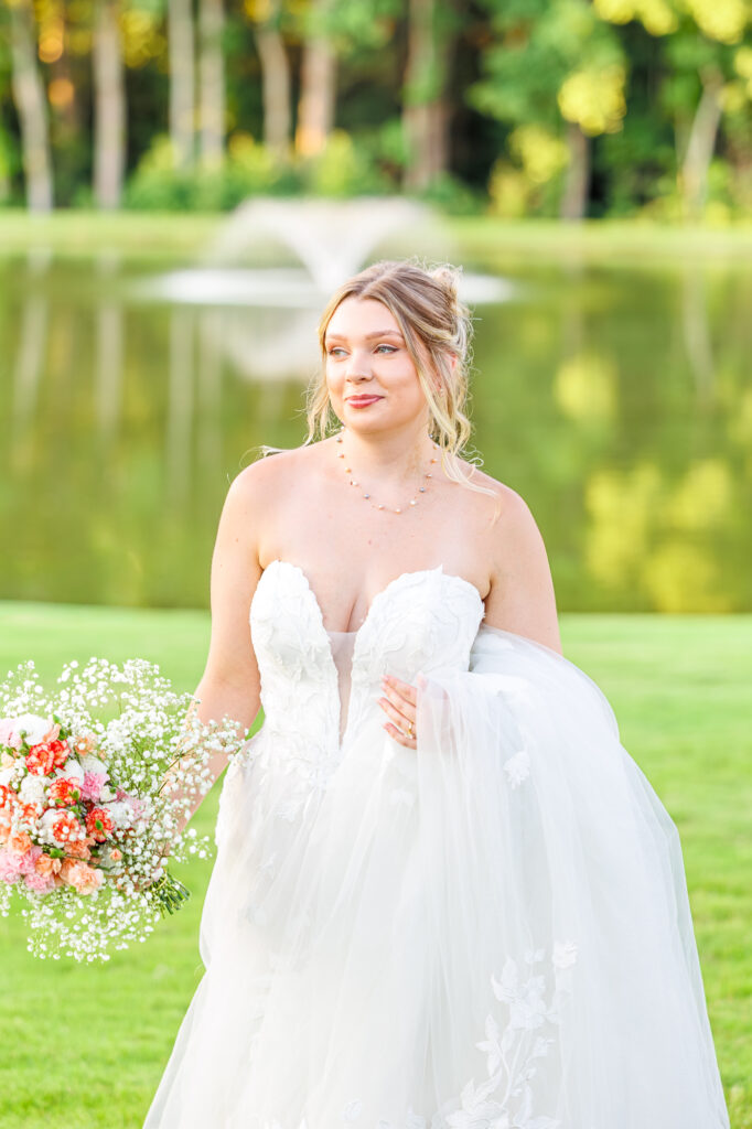 Bride in a white lace wedding gown holding a pastel bouquet at Carrollock Farms, a rustic barn wedding venue near Raleigh, North Carolina