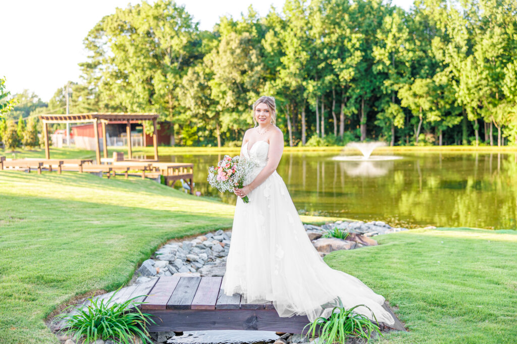 Bride in a white lace wedding gown holding a pastel bouquet at Carrollock Farms, a rustic barn wedding venue near Raleigh, North Carolina