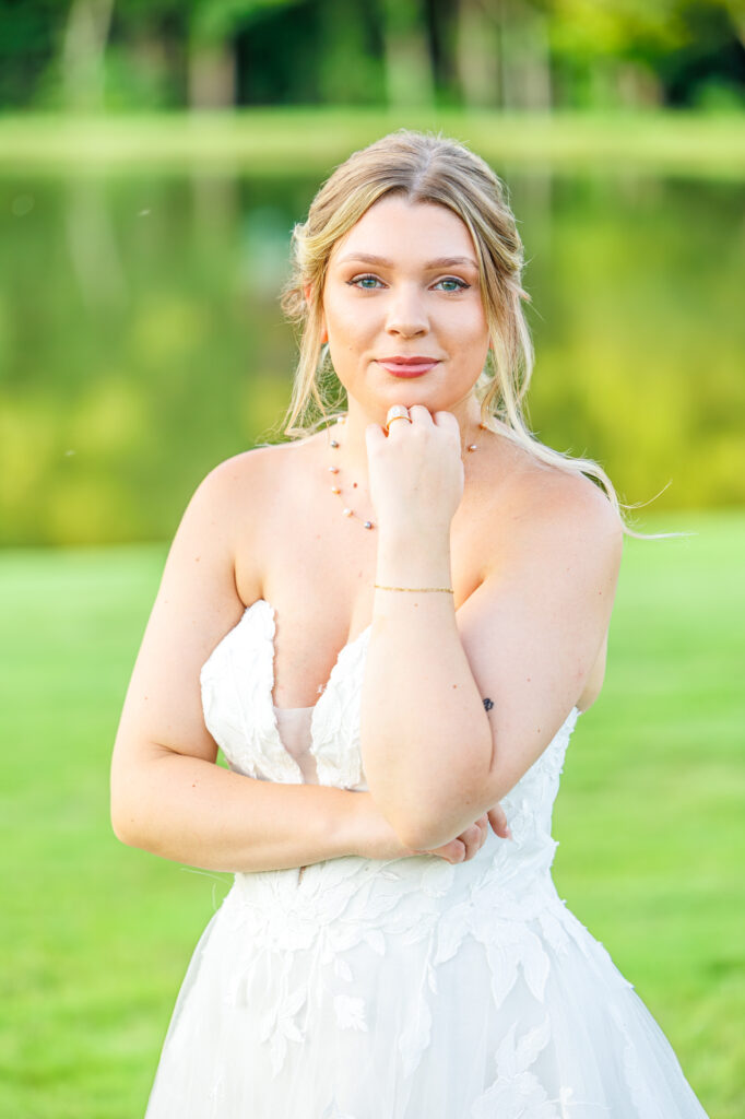 Bride in a white lace wedding gown holding a pastel bouquet at Carrollock Farms, a rustic barn wedding venue near Raleigh, North Carolina