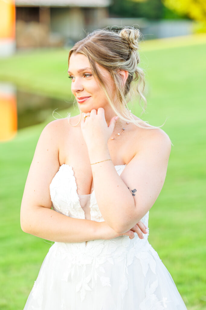 Bride in a white lace wedding gown holding a pastel bouquet at Carrollock Farms, a rustic barn wedding venue near Raleigh, North Carolina