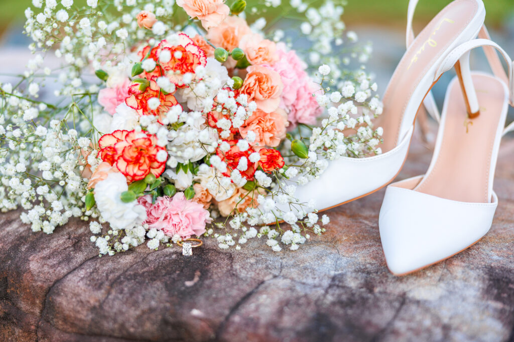 Bride in a white lace wedding gown holding a pastel bouquet at Carrollock Farms, a rustic barn wedding venue near Raleigh, North Carolina